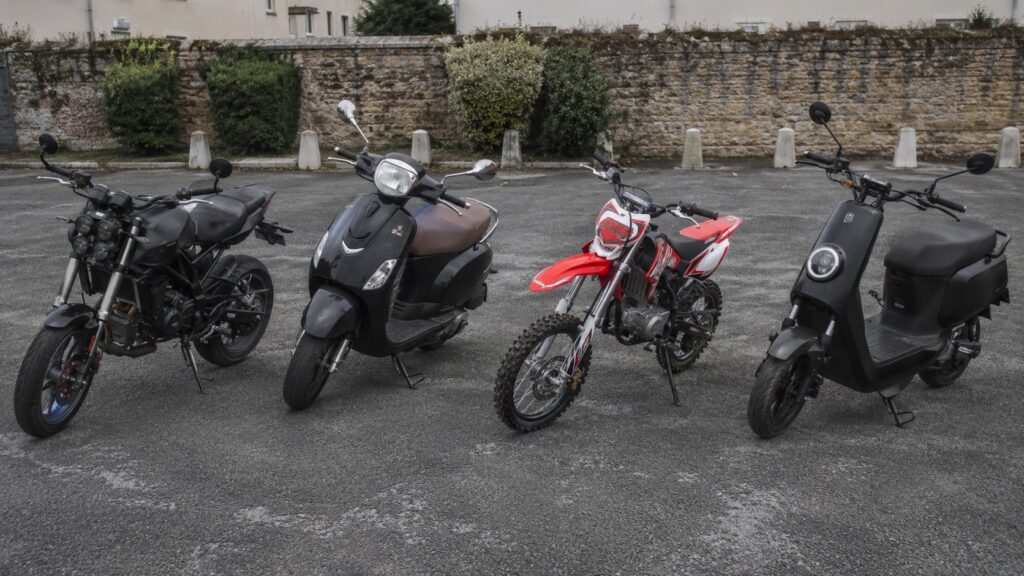 Comparer les 50cc : le bon choix dépend de l'usage réel, pas du badge comparatif 50cc 2026 scooter moto cross electrique sur parking urbain