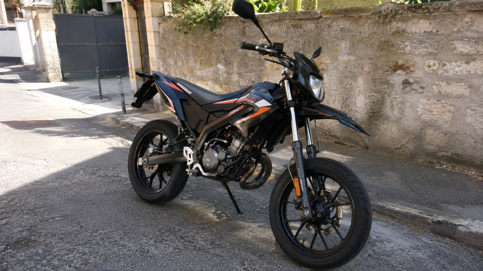 Moto 50cc homologuée stationnée dans une rue résidentielle, illustrant le choix d’un deux-roues légal pour circuler en France