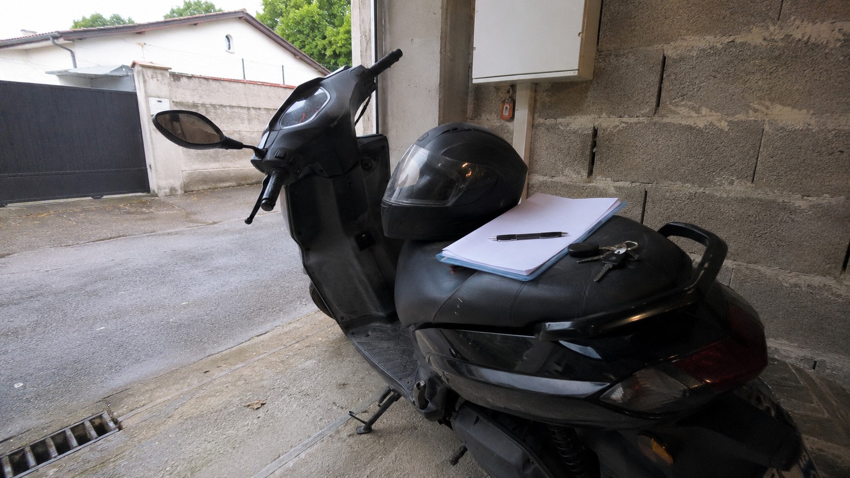 dossier d assurance, casque et cles poses sur un scooter 50cc avant signature des parents