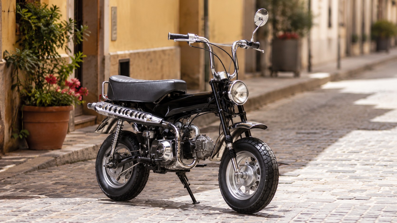 Dax 50cc noir, mini moto rétro avec selle noire, chrome, phare rond, pot latéral, roues épaisses, ruelle pavée ensoleillée, décor urbain européen, photo professionnelle réaliste, 27 juin 2026, format 16/9