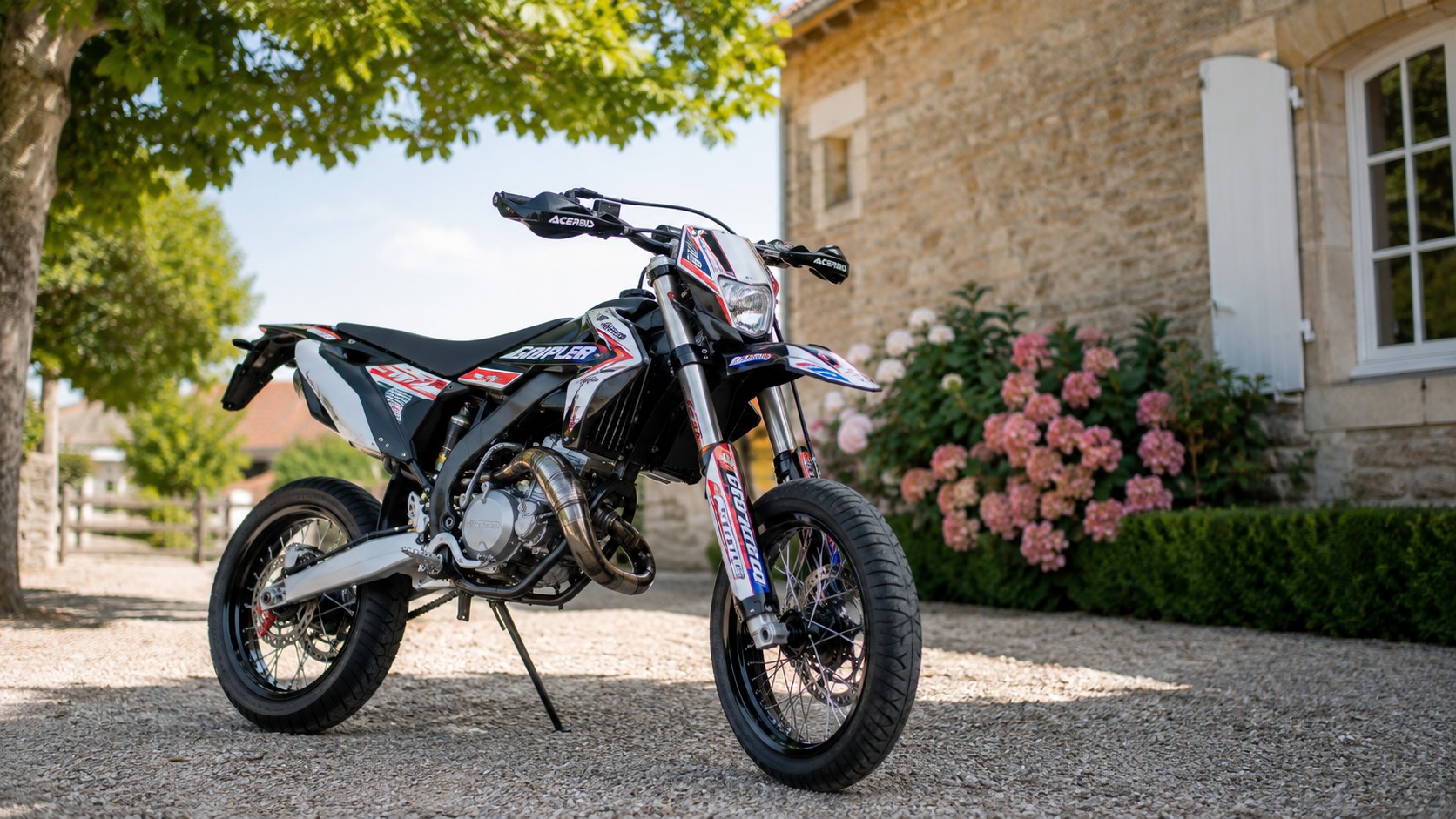 alt="supermotard 50cc devant une maison campagnarde avec allée en gravier jardin fleuri ensoleillé photo professionnelle ultra réaliste 2026 format 16:9"