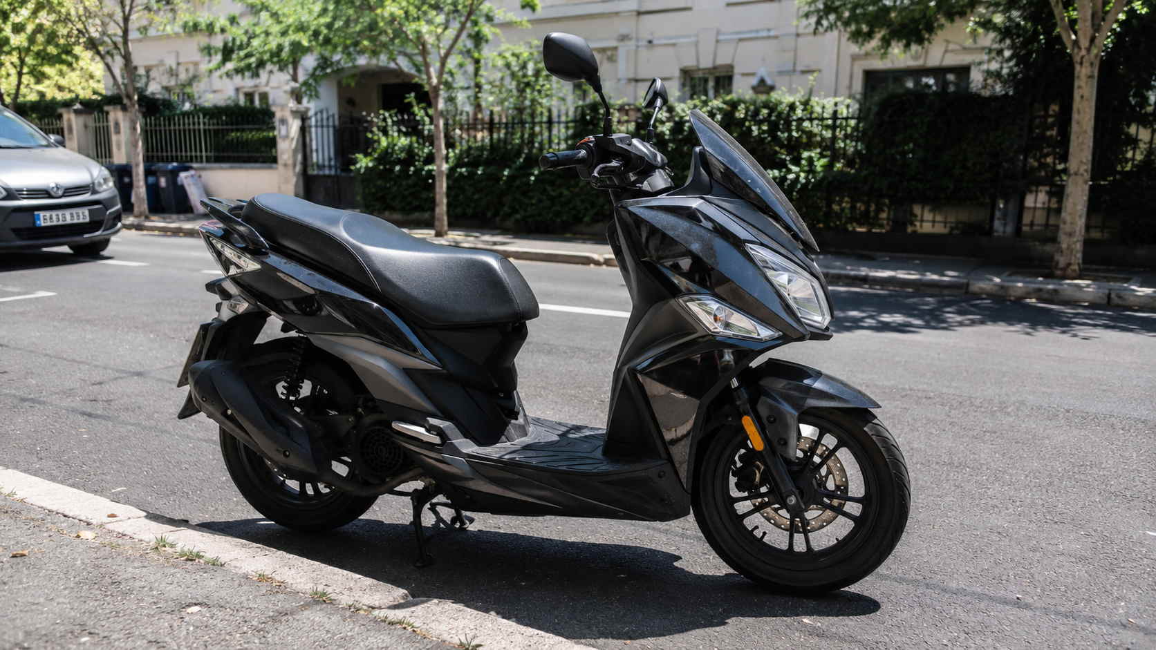 SYM Jet 14 50 cm3 noir brillant de profil cote droit, roues de 14 pouces chaussees en 100/90-14 a l'avant et 110/80-14 a l'arriere, frein a disque avant, rue parisienne